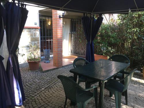 a patio with a table and chairs under an umbrella at Old Town in the green: Federico's apartment. in Florence