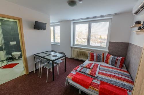 sypialnia z łóżkiem i stołem oraz łazienka w obiekcie Apartmány Vilma w mieście Lednice