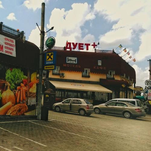 two cars parked in front of a building at Duet Plus Motel in Voytovtsy