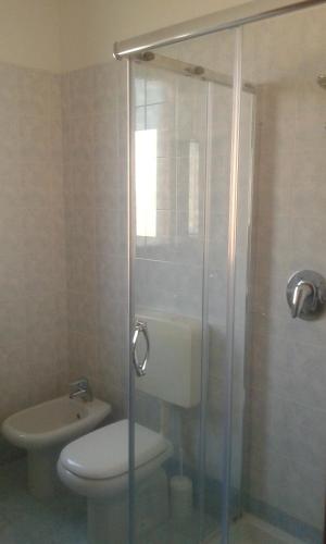 a bathroom with a toilet and a glass shower at La Cornice del Garda in Cavalcaselle