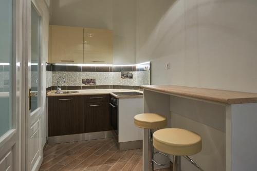 a kitchen with a counter and two stools in it at Parliament Apartment in Budapest