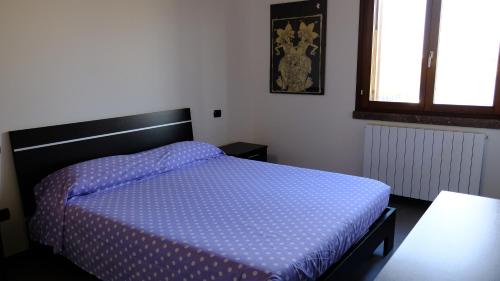 a bedroom with a bed with a blue comforter at La Baia Casa Vacanze in Portoscuso