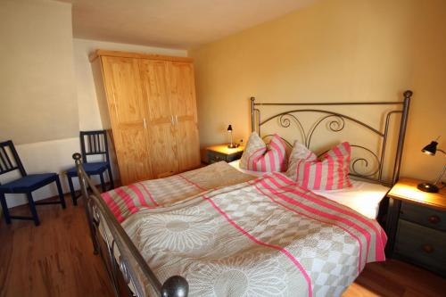 a bedroom with a large bed and two chairs at Hainich-Zeit in Eigenrieden