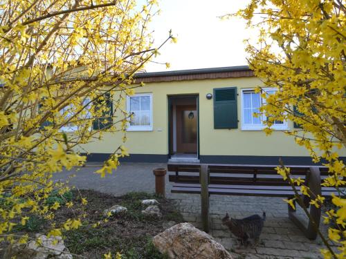 ein gelbes Haus mit einer Bank davor in der Unterkunft Apartment in M rsdorf with terrace in Mörsdorf