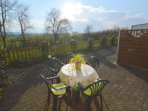 einem Tisch mit Stühlen und einer Topfpflanze darauf in der Unterkunft Apartment in M rsdorf with terrace in Mörsdorf