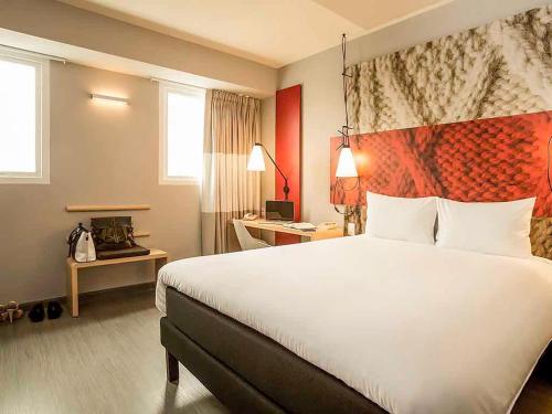 een hotelkamer met een groot bed en een bureau bij ibis Lima Reducto Miraflores in Lima