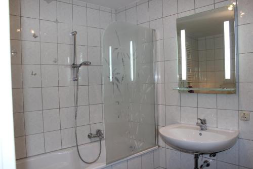 ein Bad mit einer Dusche, einem Waschbecken und einem Spiegel in der Unterkunft Altstadt-Ferienwohnung in Füssen