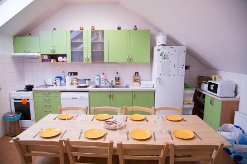 uma cozinha com armários verdes e uma mesa de madeira com cadeiras em Penzion U Rudolfů em Vlasenice