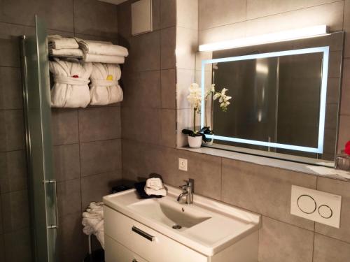 a bathroom with a sink and a mirror and towels at Bodmen 3 Apartments von Privat in Zermatt in Zermatt