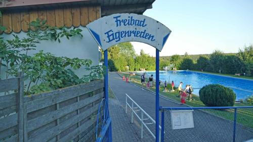 a sign for a water park with people walking around it at Hainich-Zeit in Eigenrieden