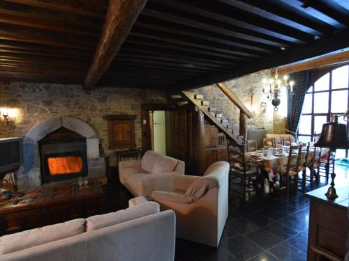a living room with white furniture and a stone fireplace at Charming Holiday Home in Halleux with Garden in Halleux
