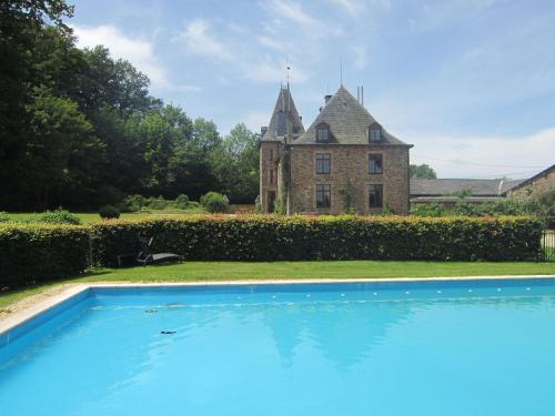 an old house with a swimming pool in front of it at Luxurious Castle with Private Pool and Sauna in Basse-Bodeux