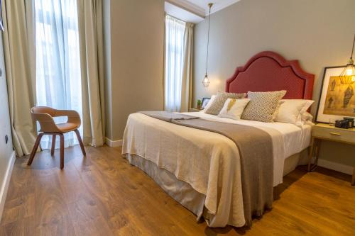 
a bed sitting in a bedroom next to a window at Bairro Alto Suites in Lisbon
