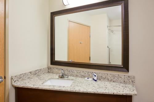 a bathroom with a sink and a mirror at AmericInn by Wyndham Hawley in Hawley
