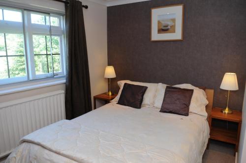 a bedroom with a white bed and two windows at Hogs Head Hotel in Nottingham