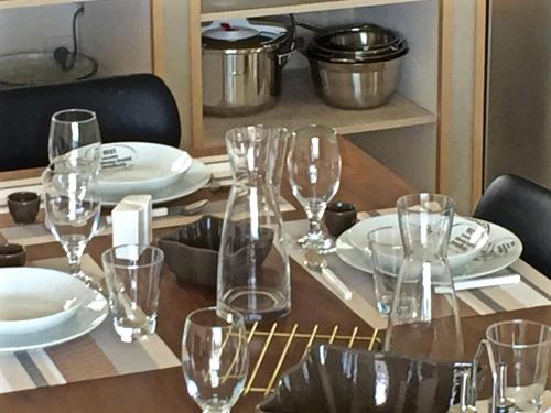a wooden table with glasses and plates on it at Les Villas MarInCelu in Porto Pollo
