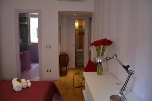 una stanza con un letto e un tavolo con un vaso di fiori di Luci della città Palazzo San Matteo a Palermo