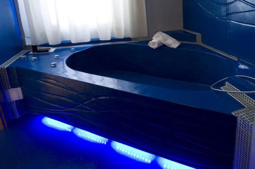 a blue bathroom with a tub with blue lights at Hotel Bella 'Mbriana in Follonica