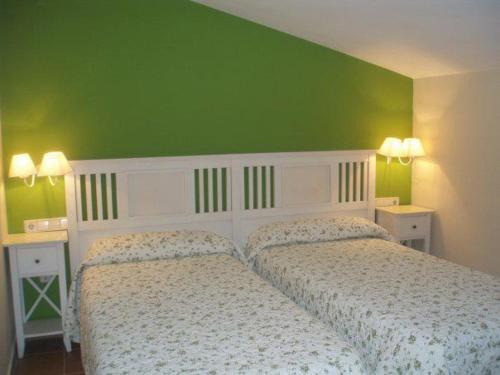 1 dormitorio con 2 camas y pared verde en Arcas de Agua, en Arcas