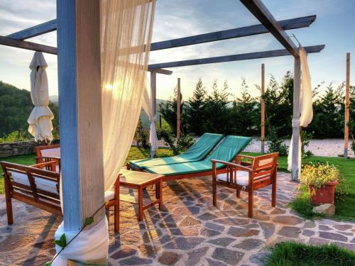 a patio with chairs and a hammock on a patio at Tasteful holiday home in Modigliana with garden in Modigliana