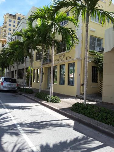 a building with palm trees in front of a street at Hotel Ponce de Leon in Miami