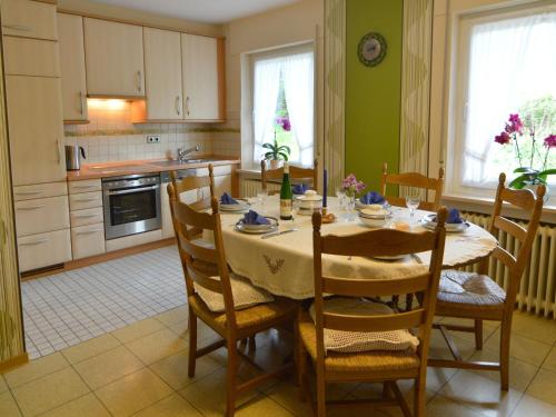 a kitchen with a table and chairs in a room at Holiday home in Densborn with garden in Zendscheid