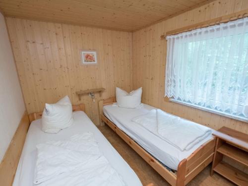 two beds in a small room with a window at Harz Home with Outdoor Space in Ilfeld