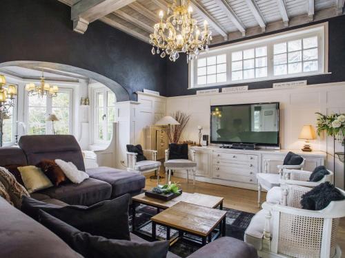 a living room with a couch and a tv at Beautiful villa 200 metres from the sea in Koksijde