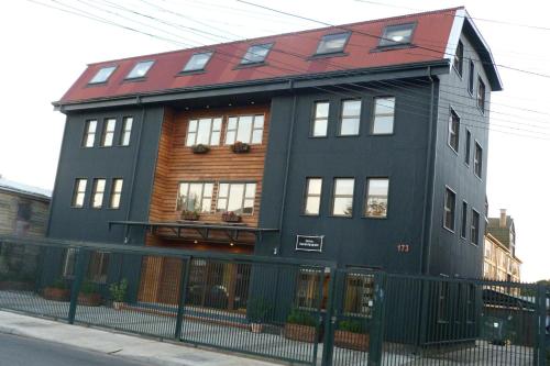 a black building with a red roof at Edificio Guadalauquen in Valdivia