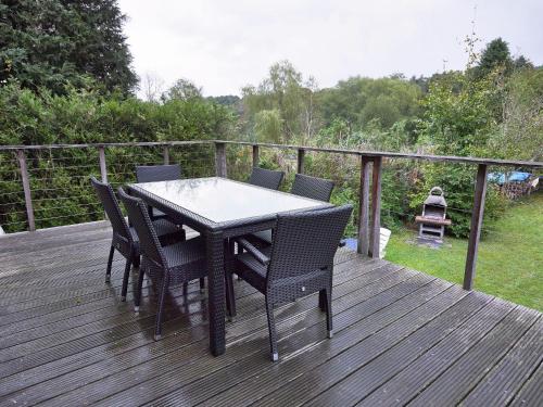 einen Tisch und Stühle auf einer Holzterrasse in der Unterkunft Holiday Home in Chevron with Garden Terrace BBQ Parking in Neucy