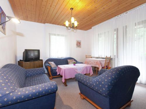 a living room with chairs and a table with a tv at Comfortable apartment in Baiersbronn with balcony in Buhlbach