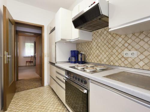 a kitchen with white cabinets and a stove top oven at Comfortable apartment in Baiersbronn with balcony in Buhlbach