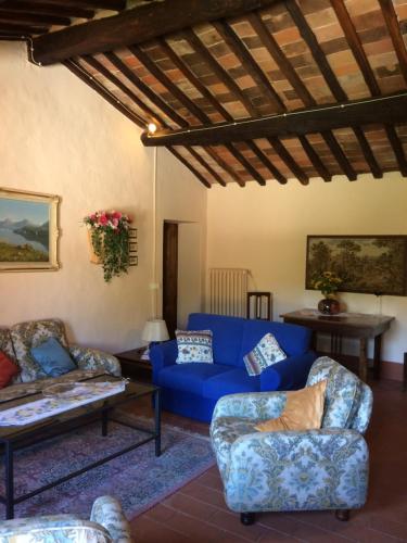 a living room with a blue couch and chairs at Podere Gnocchi in Rapale