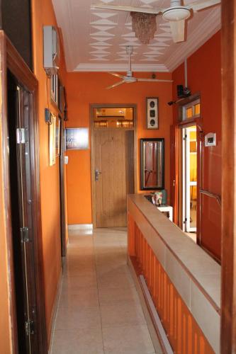 a hallway with orange walls and a door at Jesiwa B's Little Palace in Accra