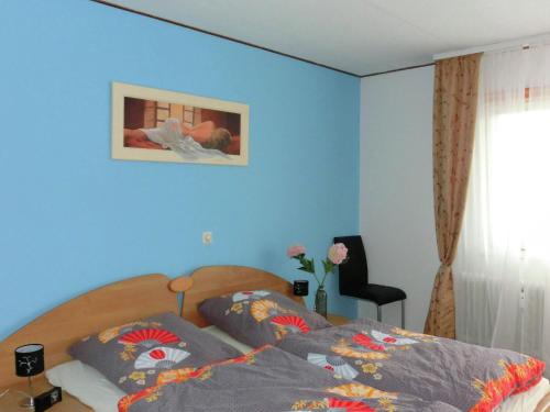 ヴィルデマンにあるMesmerizing Apartment in Wildemann Germany with Gardenの青い壁のベッドルーム1室(ベッド1台付)