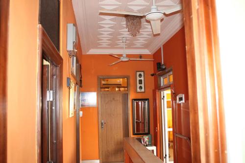 a hallway with orange walls and a hallway with a door at Jesiwa B's Little Palace in Accra