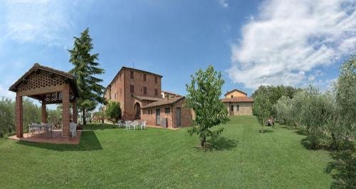 a large yard with a building and a gazebo at Albergo La Foresteria in Bettolle
