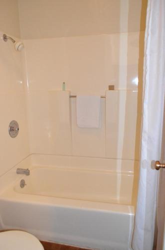 a white bathroom with a tub and a toilet at National 9 Inn Wellington in Wellington