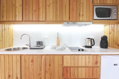 a kitchen with a sink and a microwave at World's Nests Furnas Pods Village in Furnas