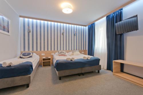 a hotel room with two beds and a television at B&B Molo in Sopot