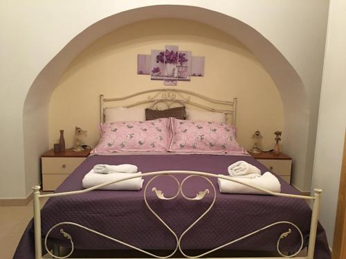 ナルドにあるJuliet's houseのベッドルーム1室(紫のシーツとタオルが備わるベッド1台付)