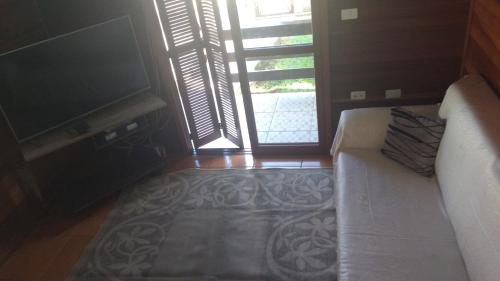 a living room with a couch and a window at Chale Verde in Gramado