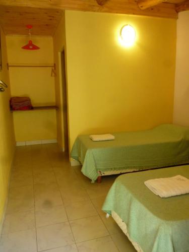 a room with two beds and a yellow wall at Valle de Epuyen in Epuyén