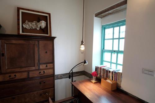 Cette chambre comprend une commode et un bureau avec des livres. dans l'établissement Yellow And Black Guest House, à Meinong