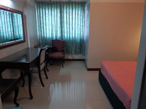 um quarto com uma mesa, uma cama e uma secretária em Sakol Hotel em Nakhon Ratchasima