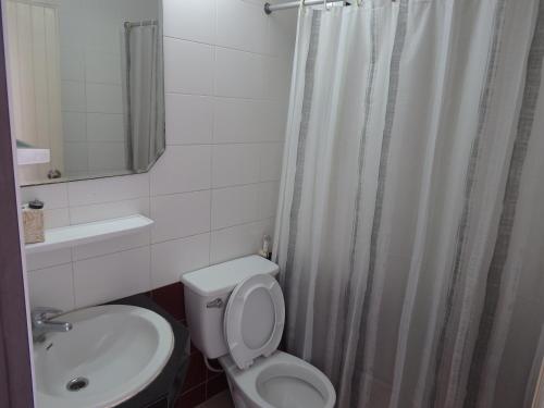 uma casa de banho com um WC branco e um lavatório. em Sakol Hotel em Nakhon Ratchasima