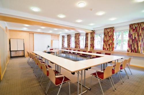 a conference room with a long table and chairs at Kolpinghaus Bolzano in Bolzano
