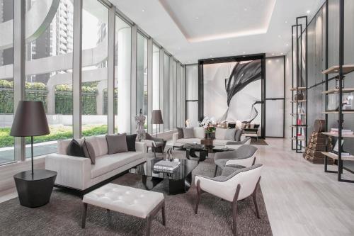 a living room with white furniture and large windows at Ascott Orchard Singapore in Singapore