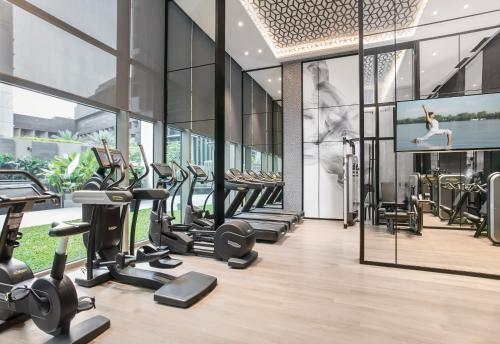 a gym with a bunch of treadmills and a tv at Ascott Orchard Singapore in Singapore