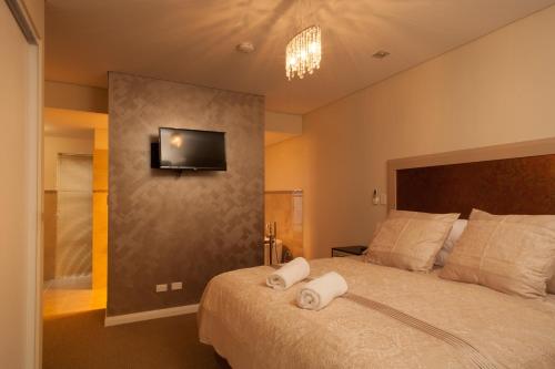 a bedroom with a bed with a television on the wall at Albany Waves in Albany